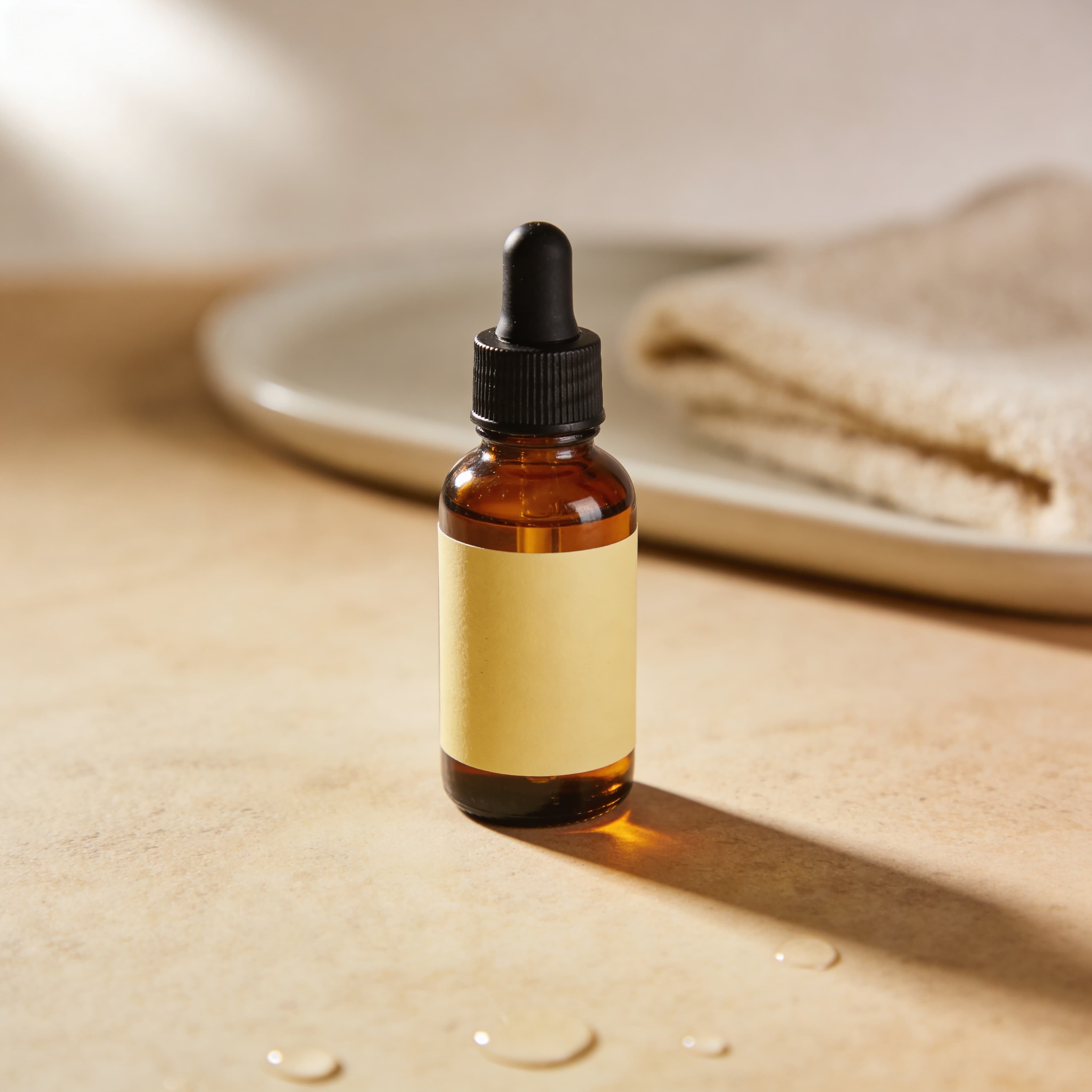 High-converting ecommerce visual of an amber glass dropper bottle in a spa-like setting
